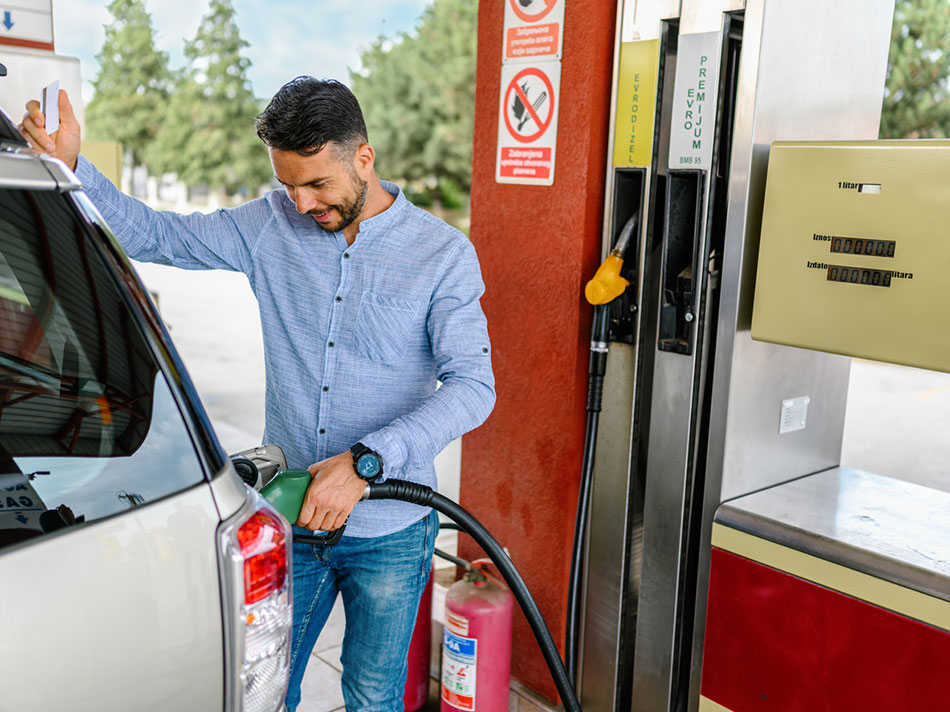 A man pumping gas and paying with his fundraising gift card.